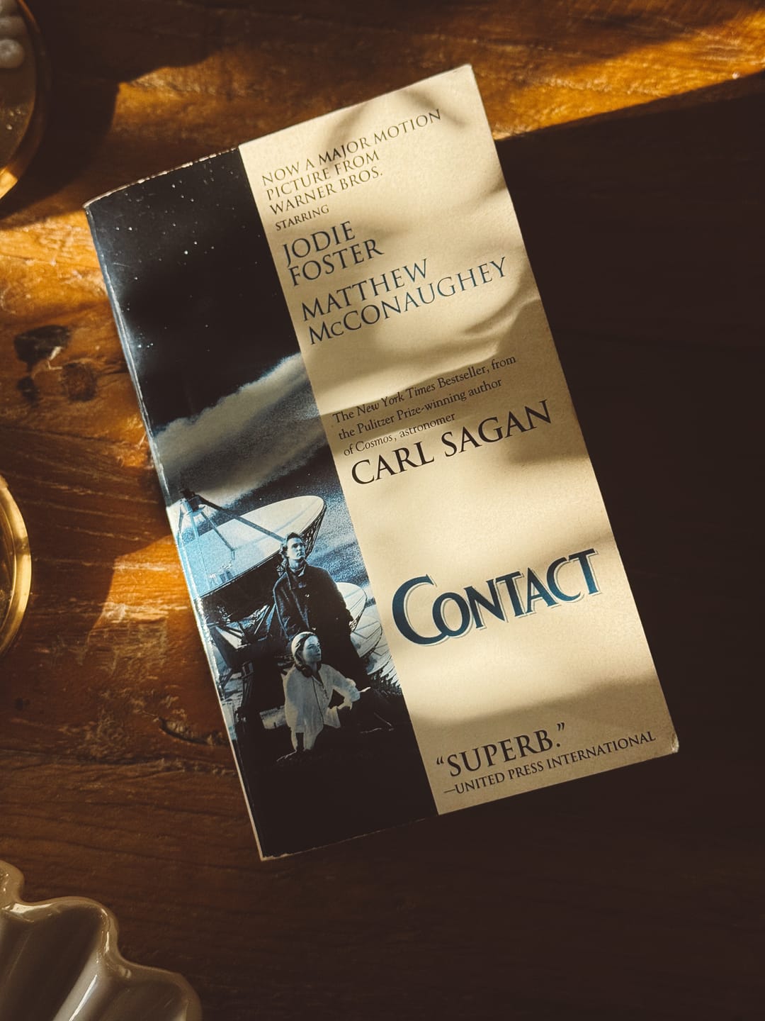 My 1997 pocket edition of the book is sitting on the kitchen table. The cover features a scene from the movie: Jodie Foster and Matthew McConaughey at the Very Large Array.