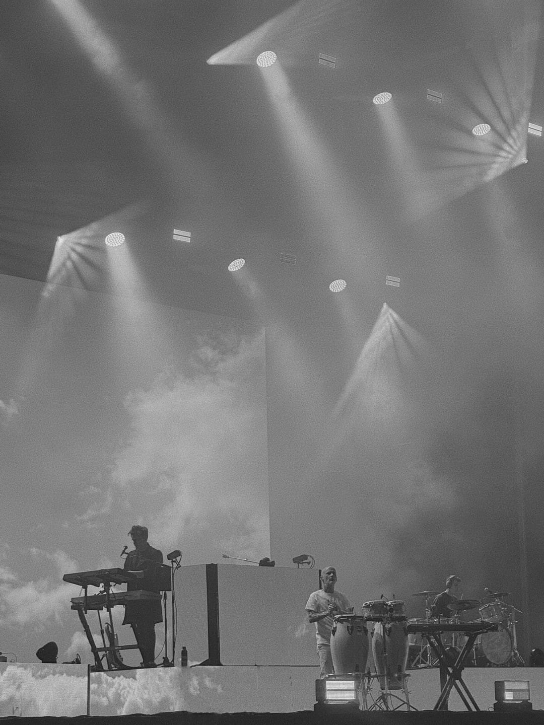Moby and bandmates playing under a wash of smoky stage lights.