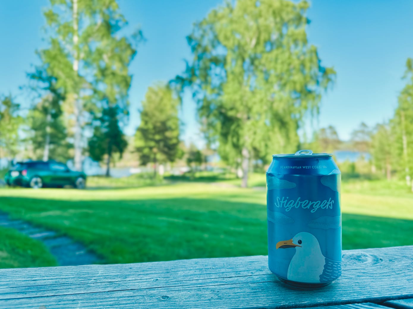 A can of Stigbergets Scandinavian West Coast IPA sits on the top step, looking out over the freshly mowed lawn under a blue sky on a nice May evening.