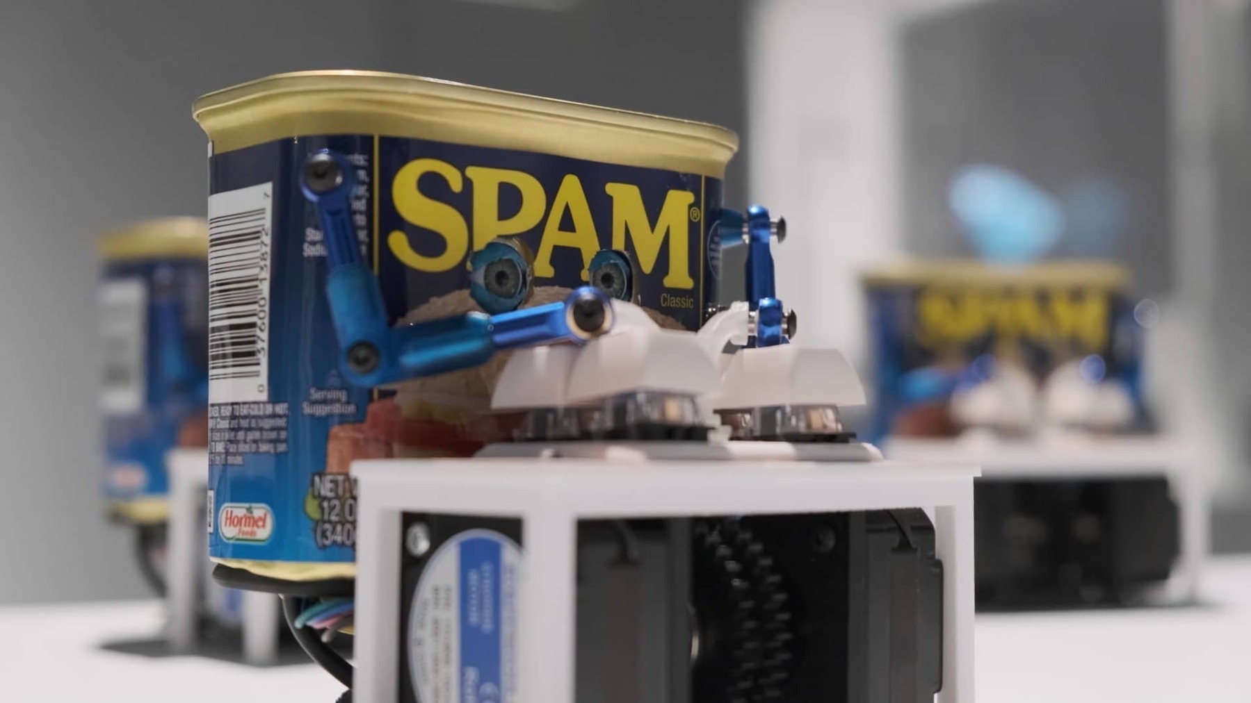 An anthropomorphized can of SPAM typing away at a tiny, four-button keyboard.