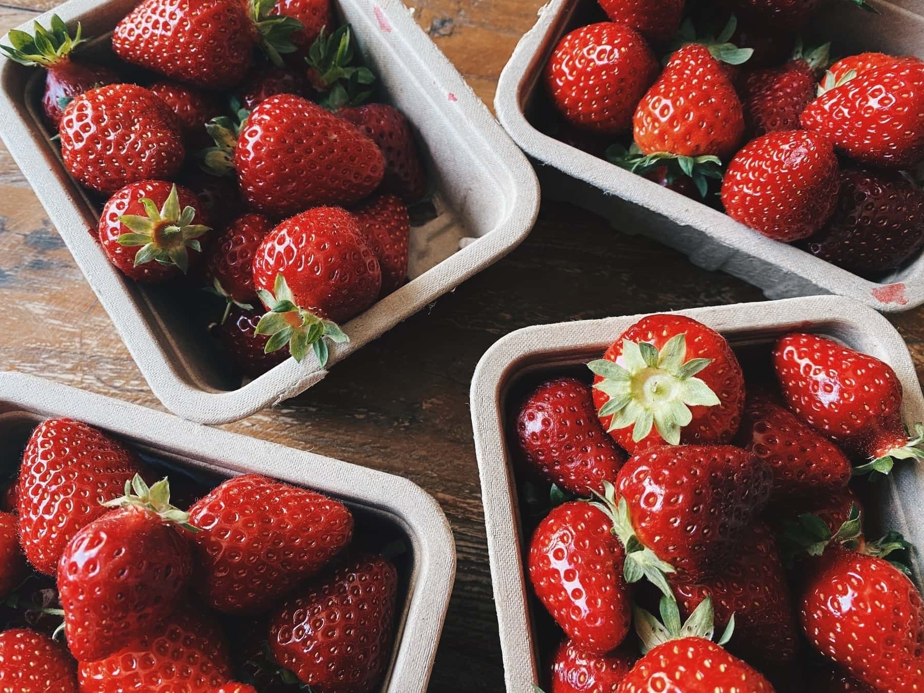 Four cartons filled with delicious-looking strawberries.