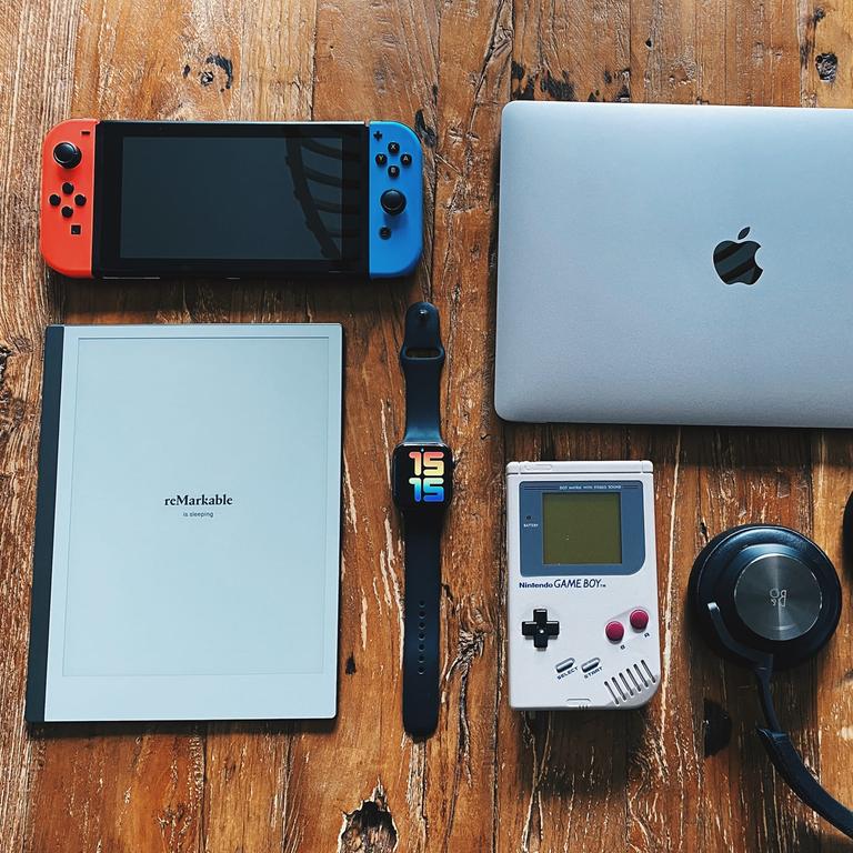 A bunch of gadgets on a wooden table. Looks like a yard sale, but you know, online.