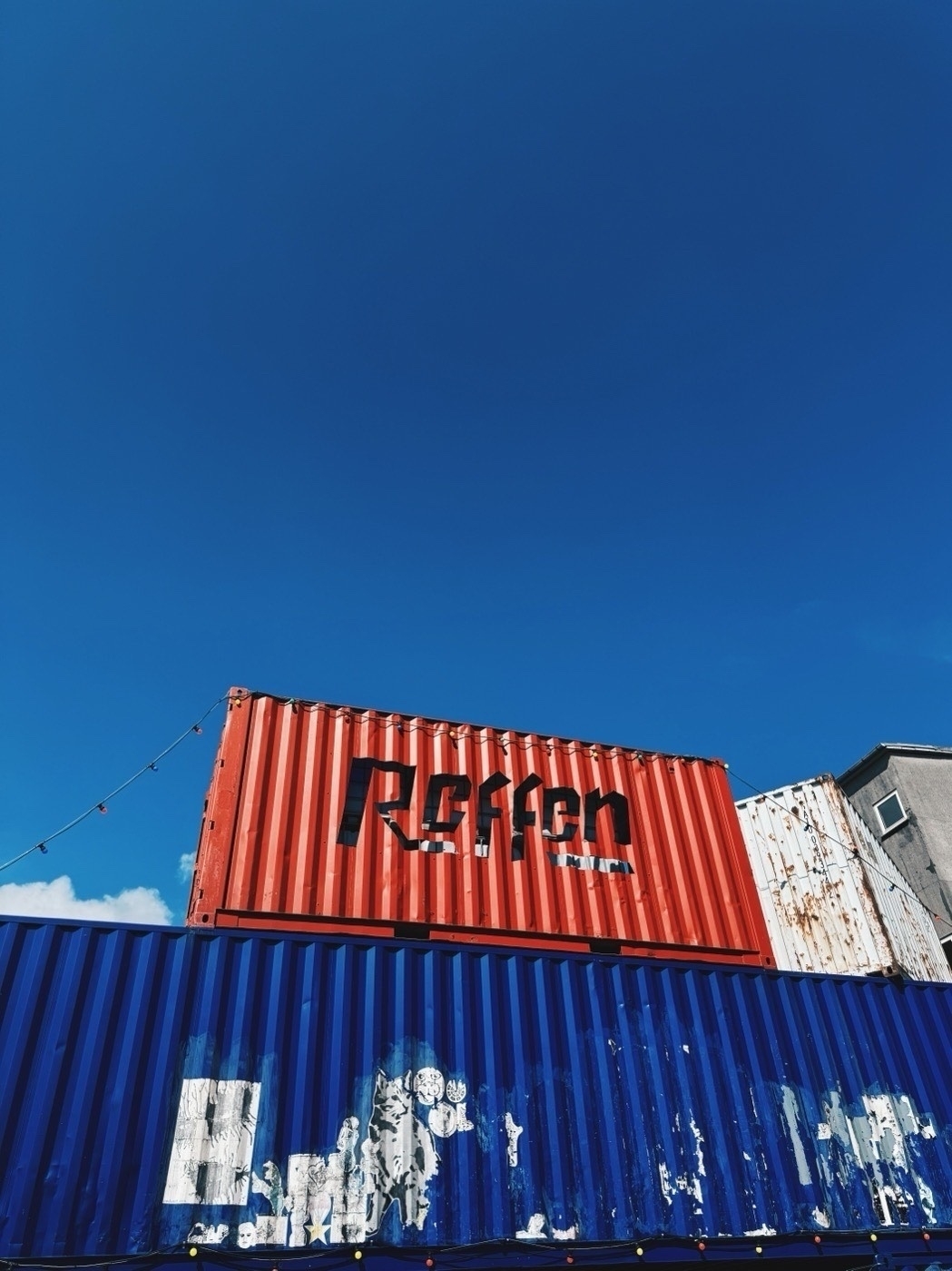 A red container atop a blue container with the word Reffen cut out.